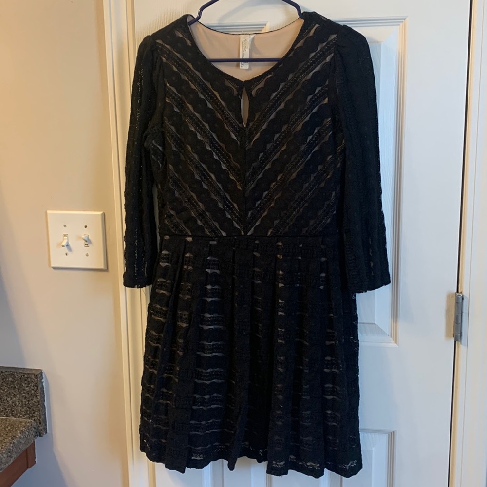 Large, lacy black dress with tan underneath